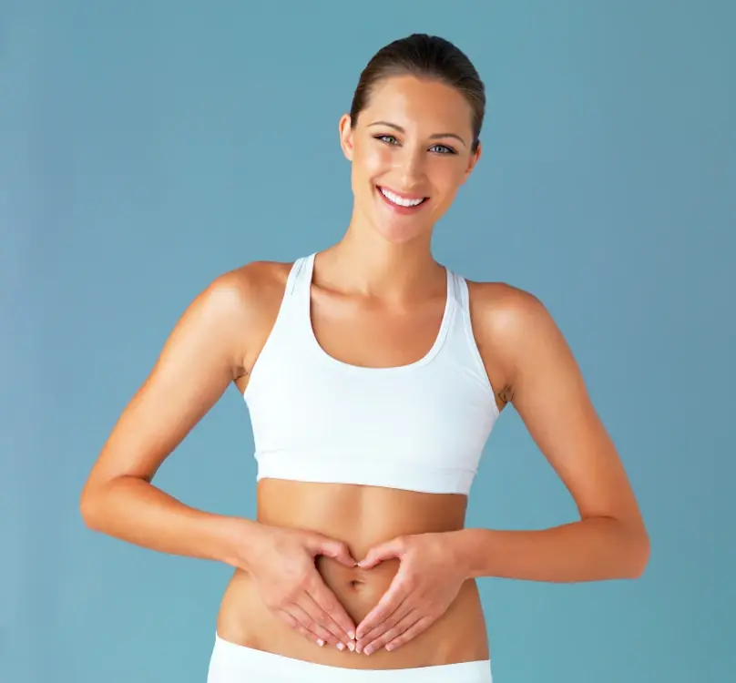 A woman making a heart shape with her hands over her stomach